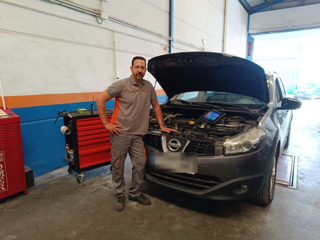 Mecánico de Talleres Ramón con la máquina de diagnosis junto Mecánico de Talleres Ramón con la máquina de diagnosis junto a un coche