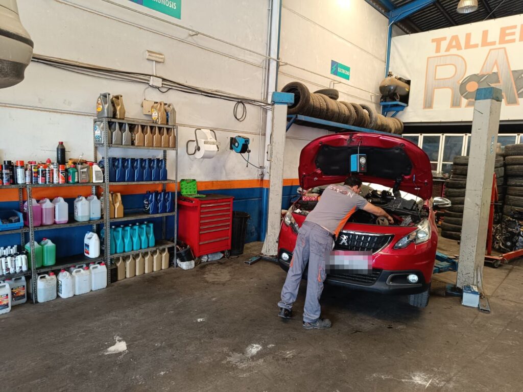 Revisión de motor en un coche con el capó abierto Revisión de motor en un coche con el capó abierto